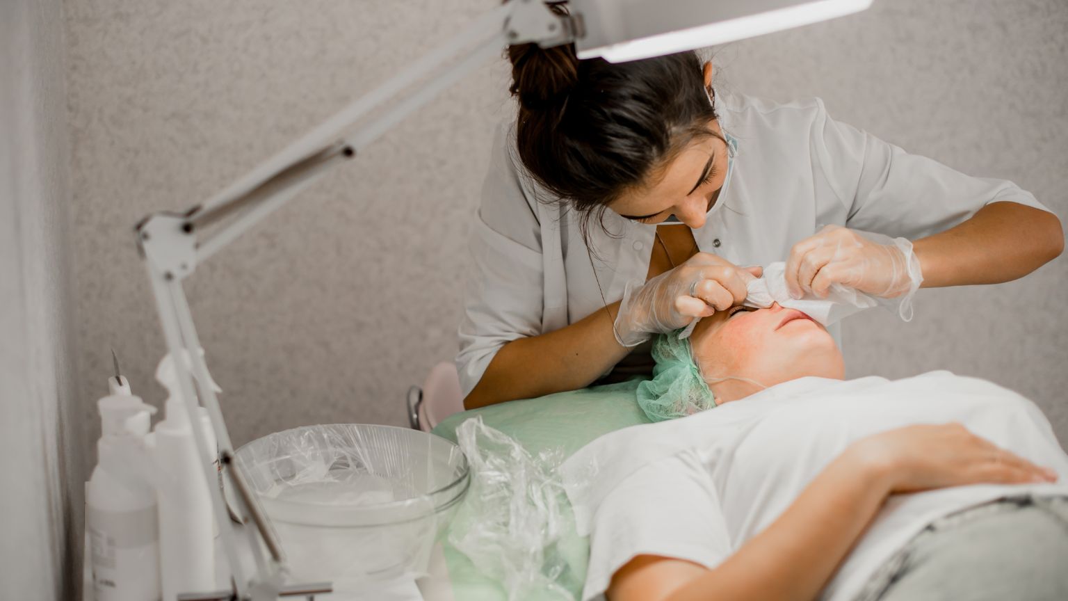 Lorena Bella Fernández realizando un tratamiento facial a pacienteacostada en camilla en Barcelona España.