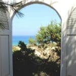 Vista al mar de Formentera, desde un portón abierto en un alojamiento para vacacionar.