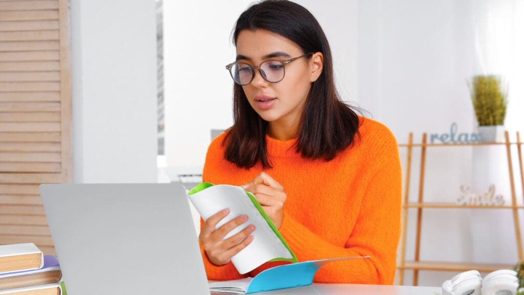 Persona estudiando un nuevo idioma en casa con materiales didácticos. Consejos para aprender idiomas de manera efectiva.