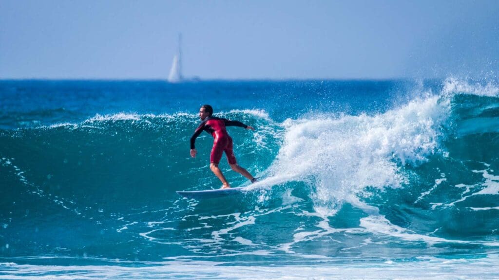 Clase de surf para principiantes en Playa de las Américas, Tenerife, con instructores y olas ideales para aprender a surfear.