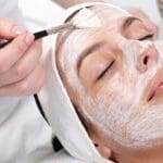 Mujer recibiendo tratamiento facial en centro de estética en Madrid, reflejando cuidados personalizados y bienestar en un entorno relajante.