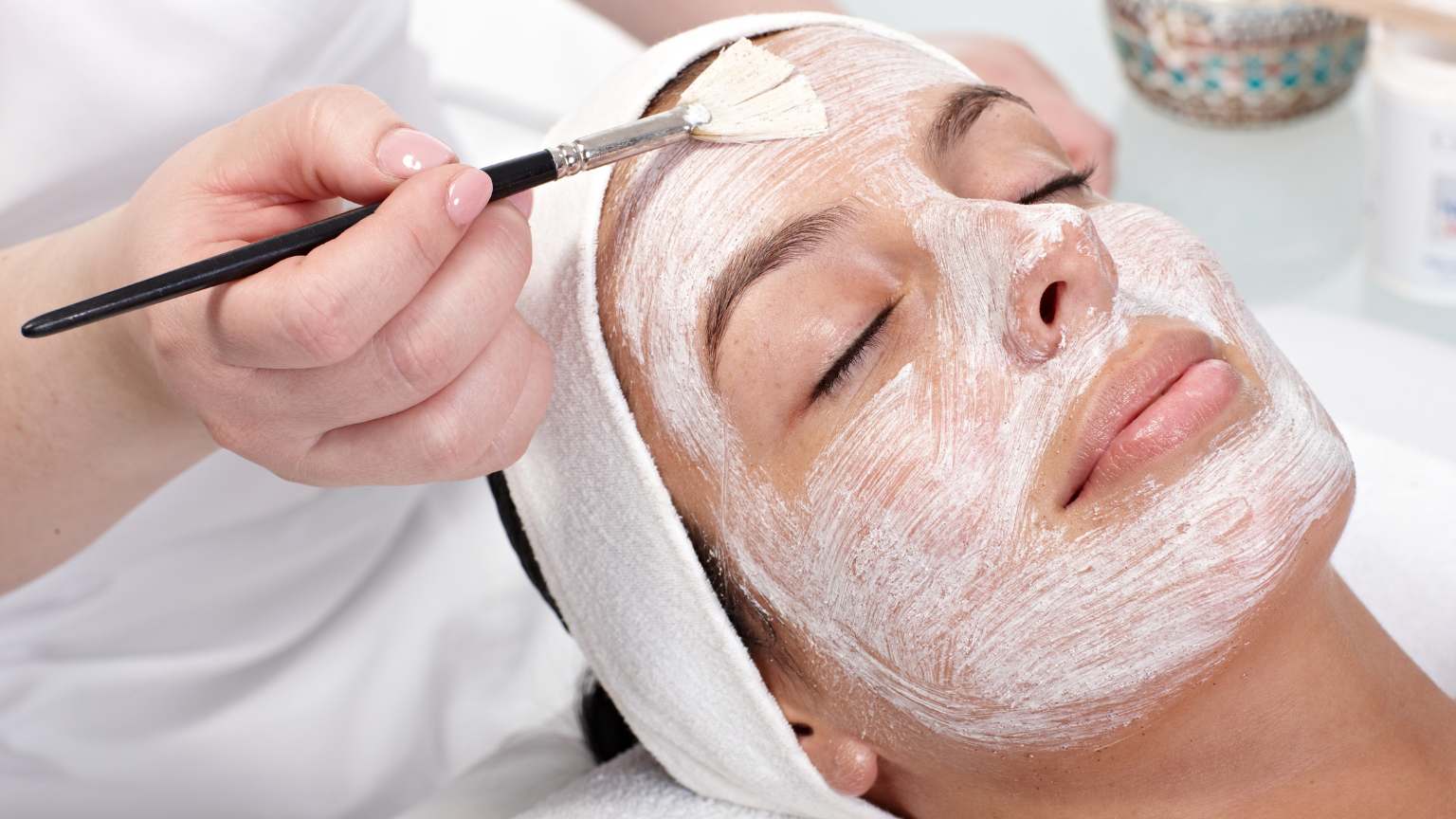 Mujer recibiendo tratamiento facial en centro de estética en Madrid, reflejando cuidados personalizados y bienestar en un entorno relajante.