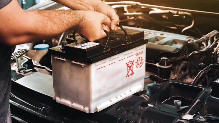 Mecánico instalando una batería de coche a domicilio en Madrid con servicio de asistencia en carretera.