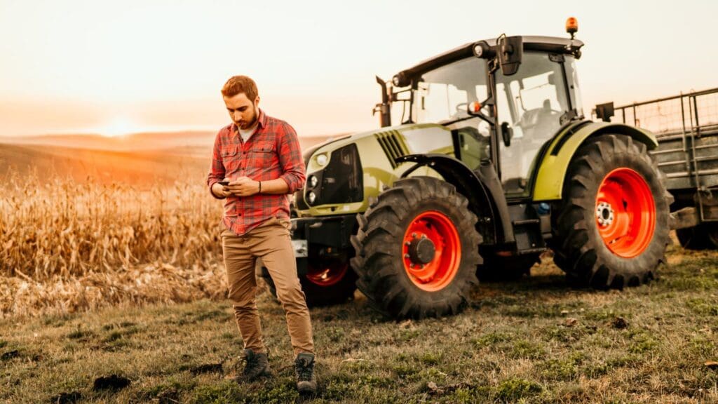 Imagen de un agricultor eligiendo maquinaria agrícola en un campo, con equipos como tractores y sembradoras.