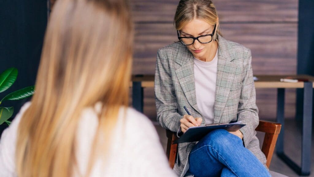 Terapeuta en sesión de psicoterapia brindando apoyo emocional y herramientas para mejorar la salud mental del paciente.