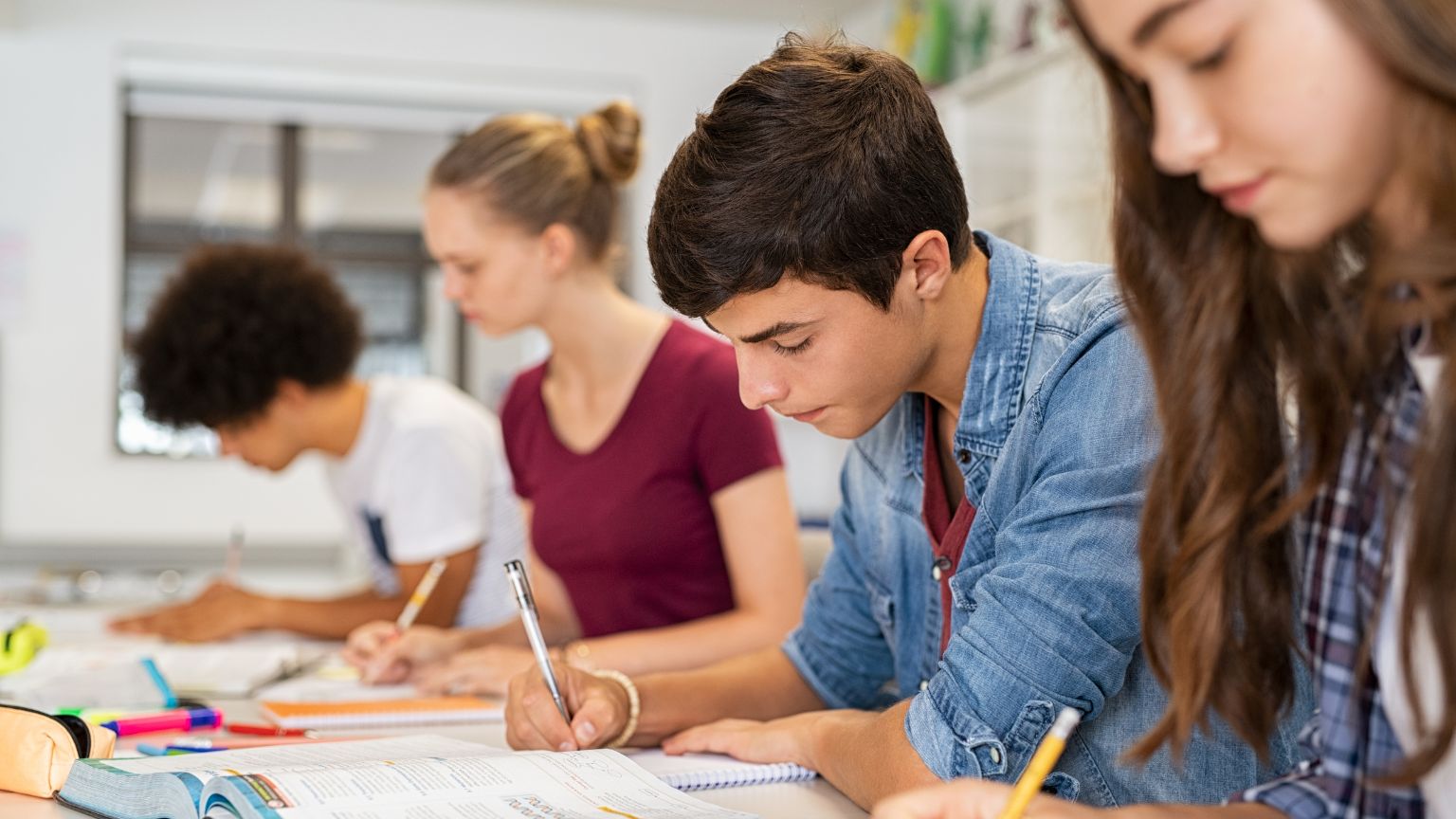 Estudiantes en una clase de apoyo escolar recibiendo refuerzo académico en grupo reducido.