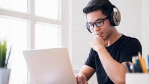 Persona preparándose para el examen de carnet de conducir mediante clases teóricas y tests online. Aprendizaje flexible desde casa con una autoescuela digital.