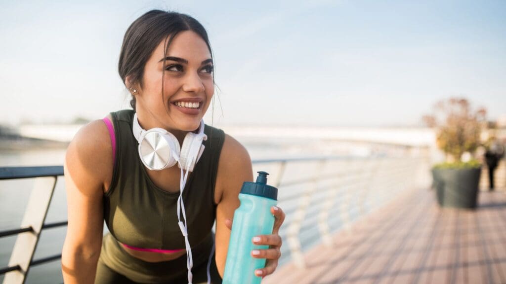 "Deportista hidratándose con agua de mar tratada, destacando los beneficios naturales de los suplementos deportivos para mejorar la hidratación y recuperación muscular.