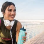 "Deportista hidratándose con agua de mar tratada, destacando los beneficios naturales de los suplementos deportivos para mejorar la hidratación y recuperación muscular.