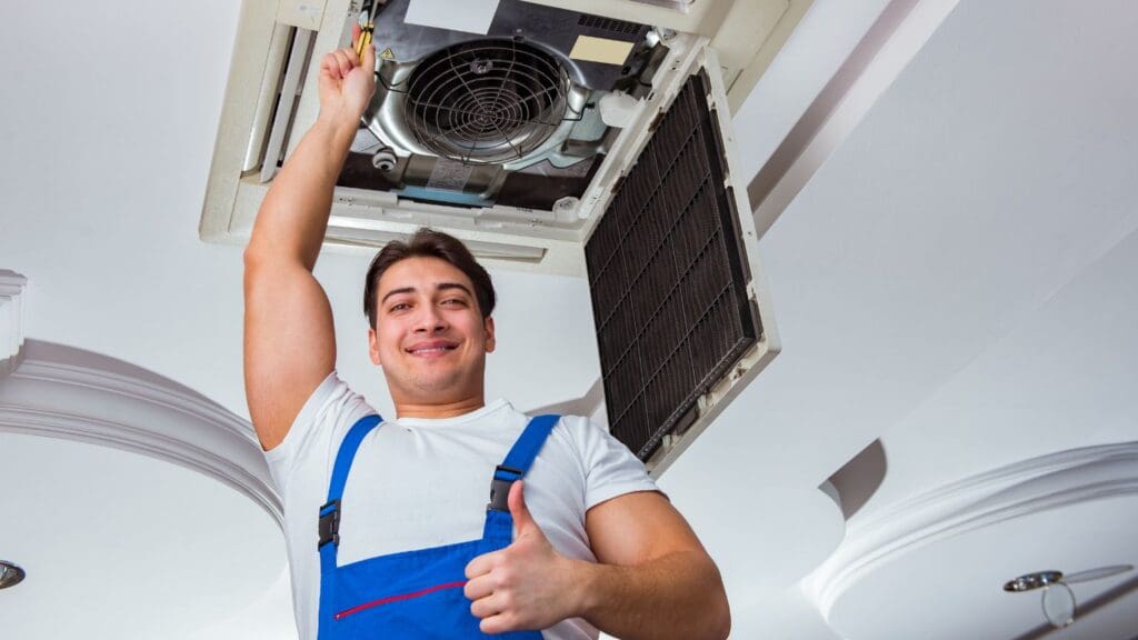 Técnico instalando un sistema de aire acondicionado en un local comercial, representando servicios profesionales de climatización para empresas.