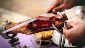 Cortador de jamón profesional realizando cortes finos de jamón ibérico en un evento en Madrid