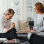 Sesión de terapia psicológica en un entorno tranquilo. Psicóloga profesional guiando a un paciente en su proceso de bienestar emocional.