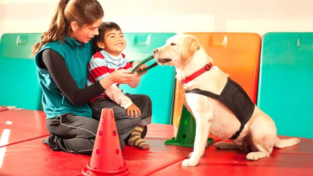 Personas de diferentes edades interactuando con perros en un entorno terapéutico, destacando los beneficios emocionales y físicos de la terapia asistida con animales.