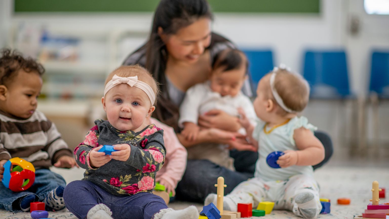 Niños pequeños jugando y aprendiendo en un entorno seguro y educativo con actividades adaptadas a su desarrollo.