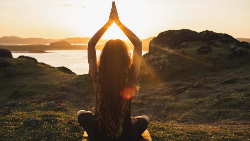 Mujer practicando yoga al aire libre, transmitiendo equilibrio, relajación y conexión interior. Ideal para reflejar bienestar y empoderamiento personal.