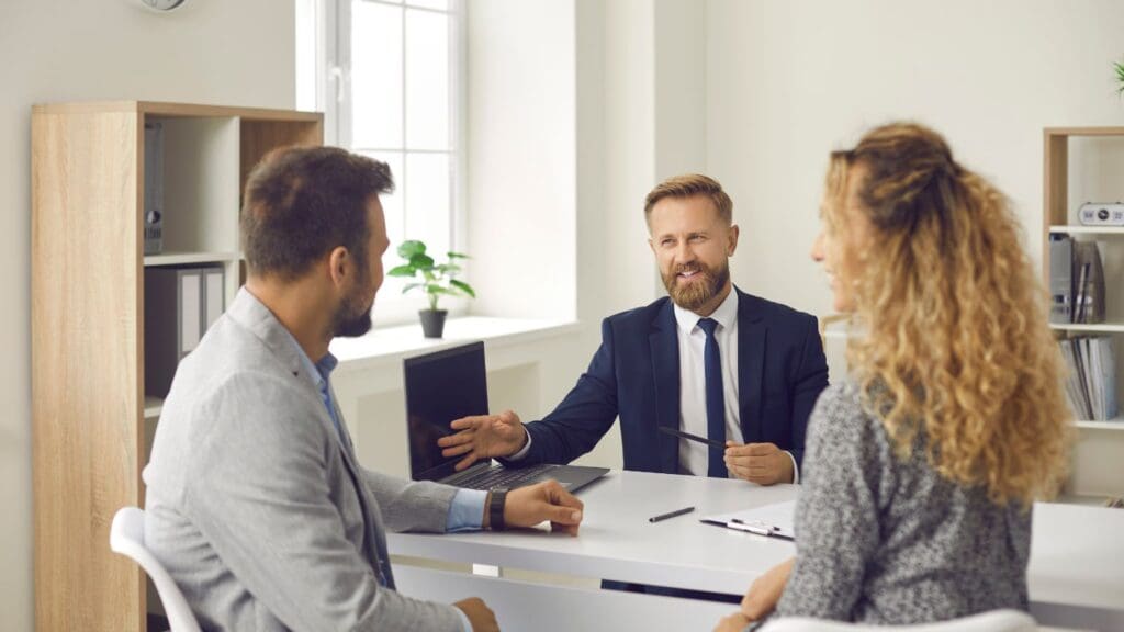 Agente de seguros en Valencia asesorando a una familia sobre pólizas de vida, hogar y planes de pensiones, destacando opciones personalizadas para sus necesidades.