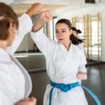 Practicantes de aikido realizando técnicas de defensa personal en un dojo japonés, enfocados en la armonía y el equilibrio.