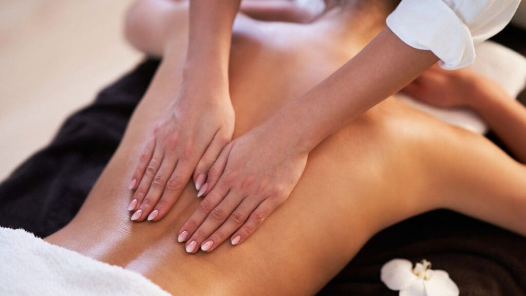 Mujer recibiendo un masaje relajante en un spa con ambiente tranquilo que promueven el bienestar y la relajación.