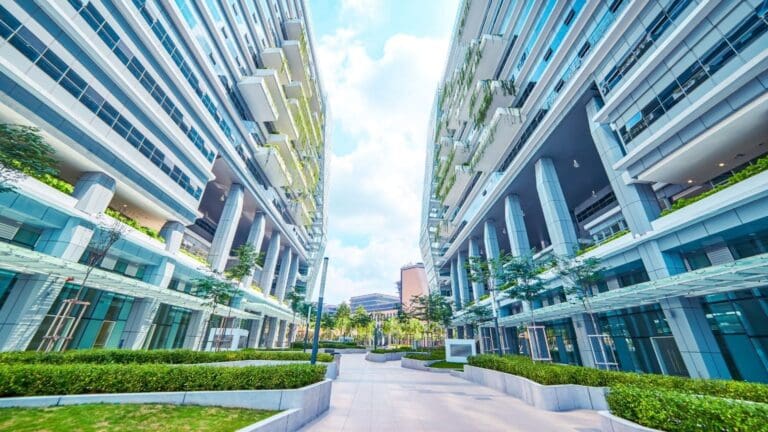 Edificio empresarial sostenible con diseño moderno, paneles solares en el techo y rodeado de naturaleza, representando la integración de sostenibilidad y funcionalidad.