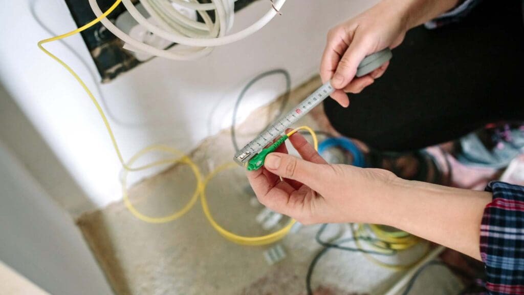 Técnico instalando antena en un hogar mientras configura sistemas de internet y telecomunicaciones en Asturias.