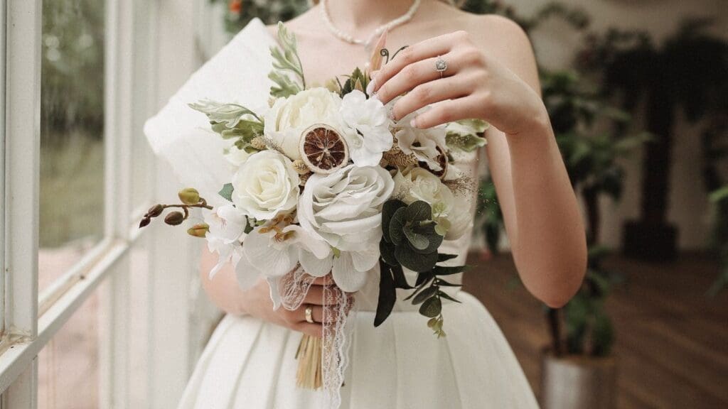 Novia con vestido de alta costura, bordado con detalles elegantes y encaje, posando en un entorno sofisticado. Perfecto para destacar exclusividad y glamour en bodas.