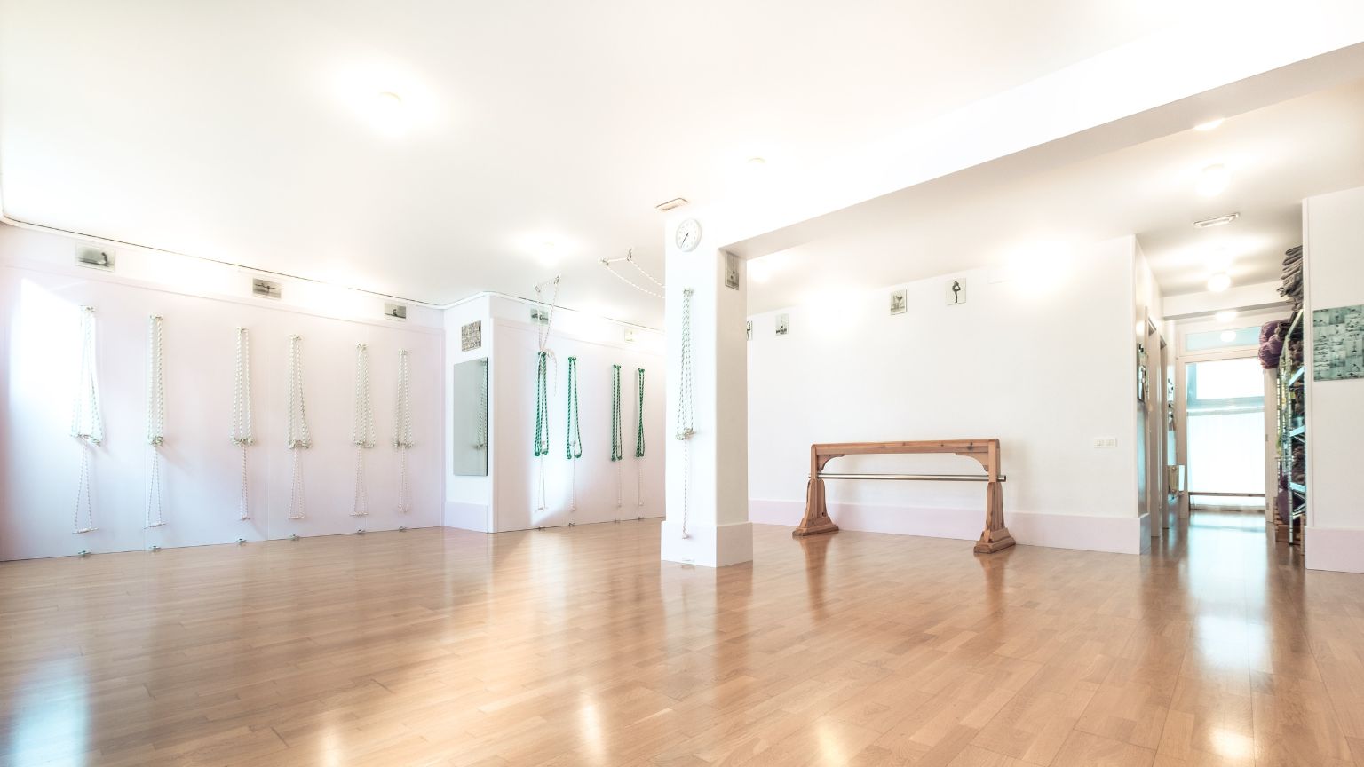 Espacio luminoso y tranquilo de un estudio de yoga Iyengar, equipado con bloques, cinturones y esterillas, ideal para la práctica enfocada en la alineación y el bienestar.