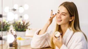 Mujer emprendedora vendiendo cosméticos desde casa, usando redes sociales para promocionar su negocio de belleza.