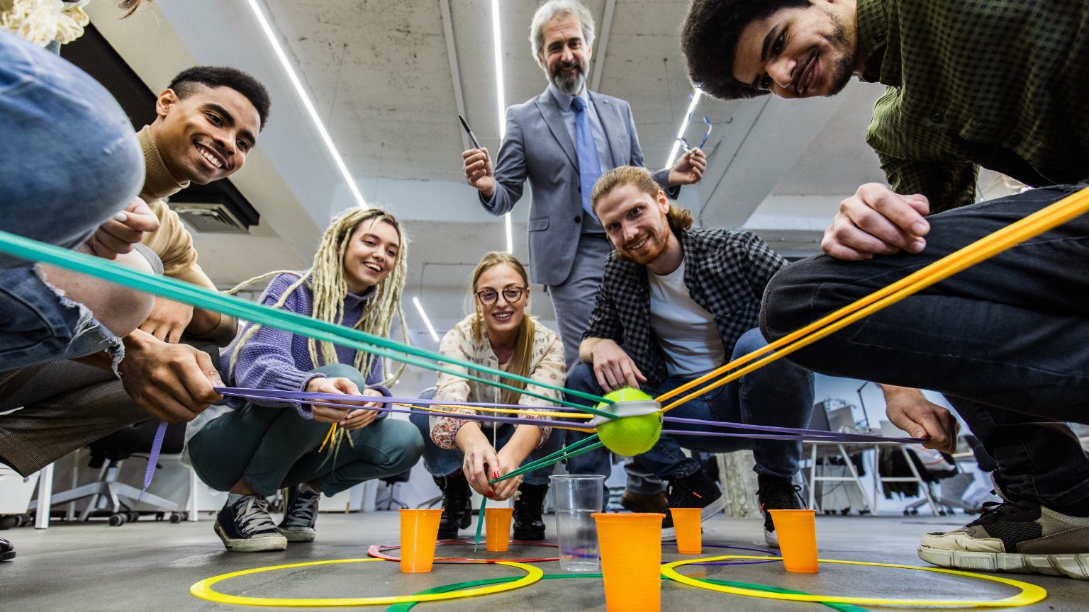 Equipo de trabajo participando en un juego interactivo para empresas, mejorando la colaboración y el aprendizaje en un entorno lúdico.