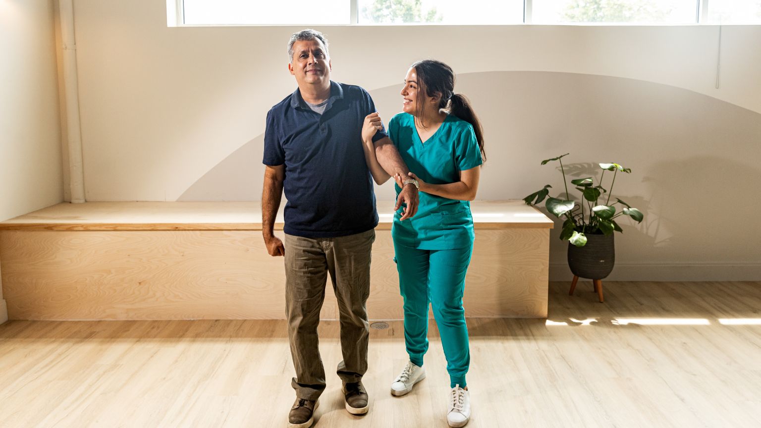 Paciente en rehabilitación con ayuda de una fisioterapeuta en un centro de terapia, reflejando apoyo y recuperación.