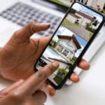 Persona buscando vivienda en España a través de su móvil con una app inmobiliaria.