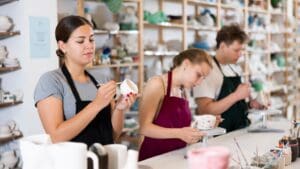 Personas pintando cerámica en un taller creativo, explorando técnicas de decoración y disfrutando de una experiencia relajante y artística.