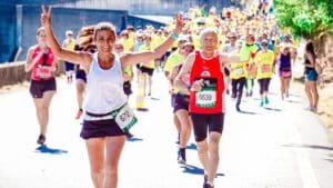 Grupo de corredores participando en un evento deportivo al aire libre, mostrando entusiasmo y energía mientras avanzan por la ruta de la competición.