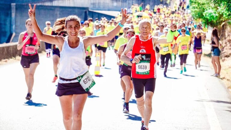 Grupo de corredores participando en un evento deportivo al aire libre, mostrando entusiasmo y energía mientras avanzan por la ruta de la competición.