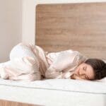 Persona descansando plácidamente sobre colchón viscoelástico en un dormitorio moderno y relajante con luz natural