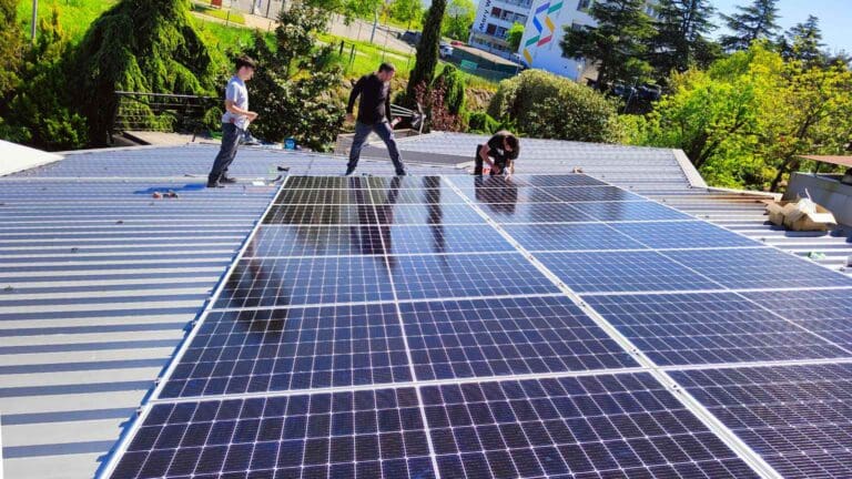 Instaladores trabajando sobre cubierta metálica durante la reforma de una instalación eléctrica con integración de paneles solares.