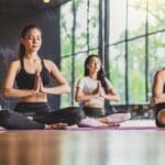 ersonas practicando cinco estilos distintos de yoga en un entorno sereno, representando la diversidad de posturas y beneficios de la práctica de yoga.