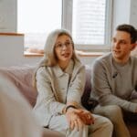 Pareja en sesión de terapia emocional trabajando su vínculo en un entorno acogedor y con acompañamiento terapéutico centrado en el aquí y el ahora.