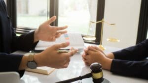 Cliente recibiendo asesoría legal en una oficina, contrastando con un proceso de defensa legal en un entorno judicial.