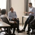 Líder transformacional guiando a su equipo a través de estrategias de coaching ejecutivo, potenciando el desarrollo y el empoderamiento profesional.