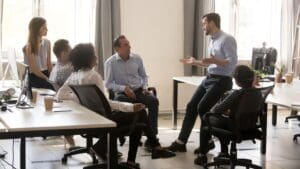 Líder transformacional guiando a su equipo a través de estrategias de coaching ejecutivo, potenciando el desarrollo y el empoderamiento profesional.