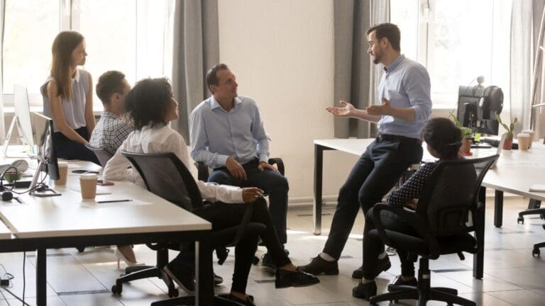 Líder transformacional guiando a su equipo a través de estrategias de coaching ejecutivo, potenciando el desarrollo y el empoderamiento profesional.