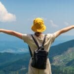 Mujer viajando sola por un paisaje natural, disfrutando de su libertad y conexión interior en una escapada inolvidable