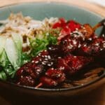 Platos de cocina fusión asiático-caribeña con presentación gourmet, combinando ingredientes tropicales y técnicas modernas en un entorno gastronómico elegante