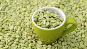 Granos de café verde sin tostar en un cuenco con fondo natural, símbolo de bebida saludable y antioxidante.
