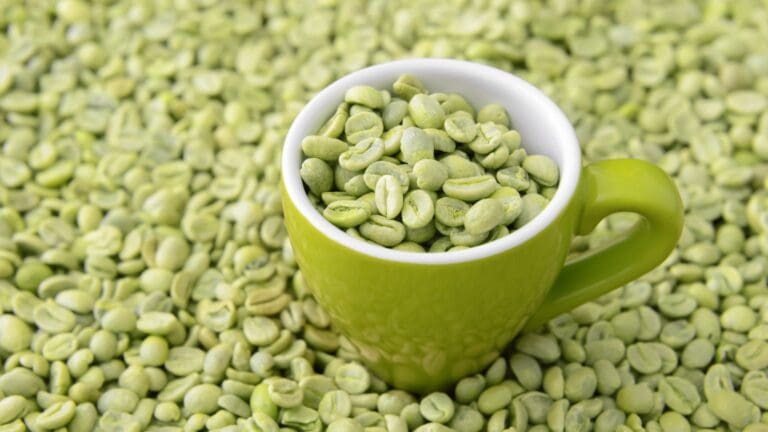 Granos de café verde sin tostar en un cuenco con fondo natural, símbolo de bebida saludable y antioxidante.