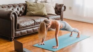 Mujer haciendo ejercicio en casa con esterilla, representando un estilo de vida saludable para perder peso de forma natural.