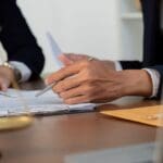 Revisión legal de proyecto urbanístico en Valencia con abogados y planos de arquitectura sobre una mesa