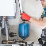 Técnico realizando mantenimiento de gas en una instalación doméstica con equipo de seguridad.
