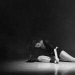 Mujer practicando danza contemporánea en estudio luminoso con movimiento libre y ropa cómoda