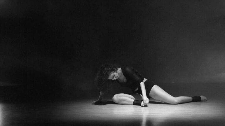 Mujer practicando danza contemporánea en estudio luminoso con movimiento libre y ropa cómoda